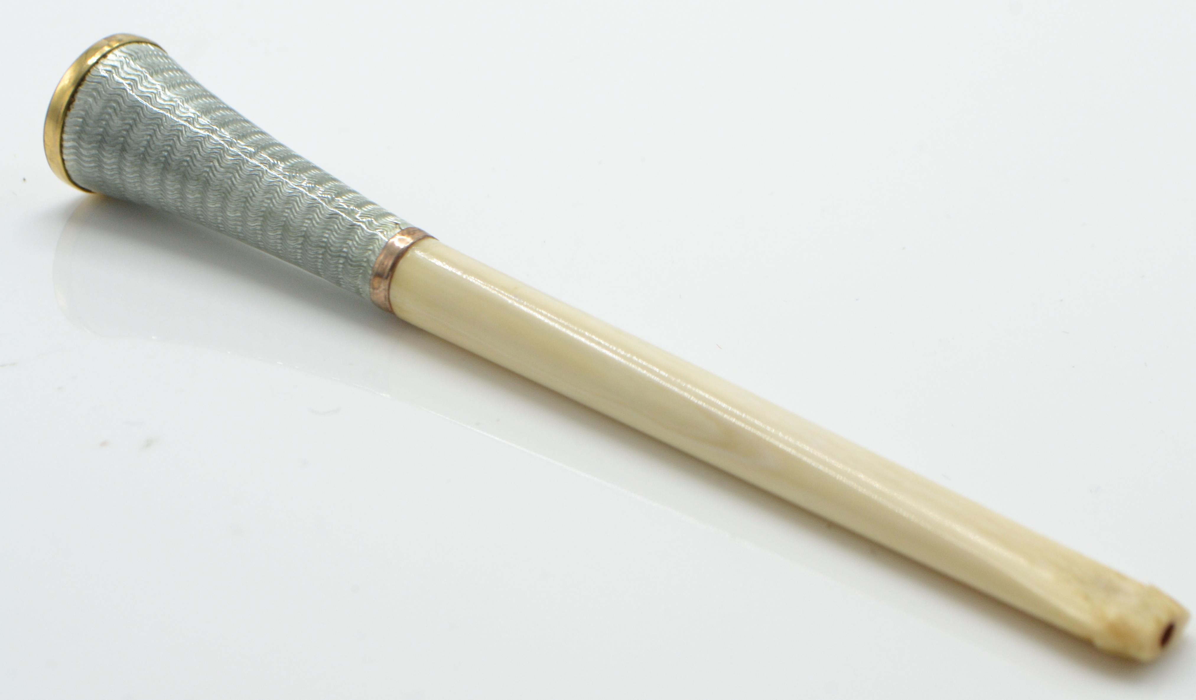A 1930's Art Deco guilloche enamelled ivory cigarette holder. The ivory neck with enamelled