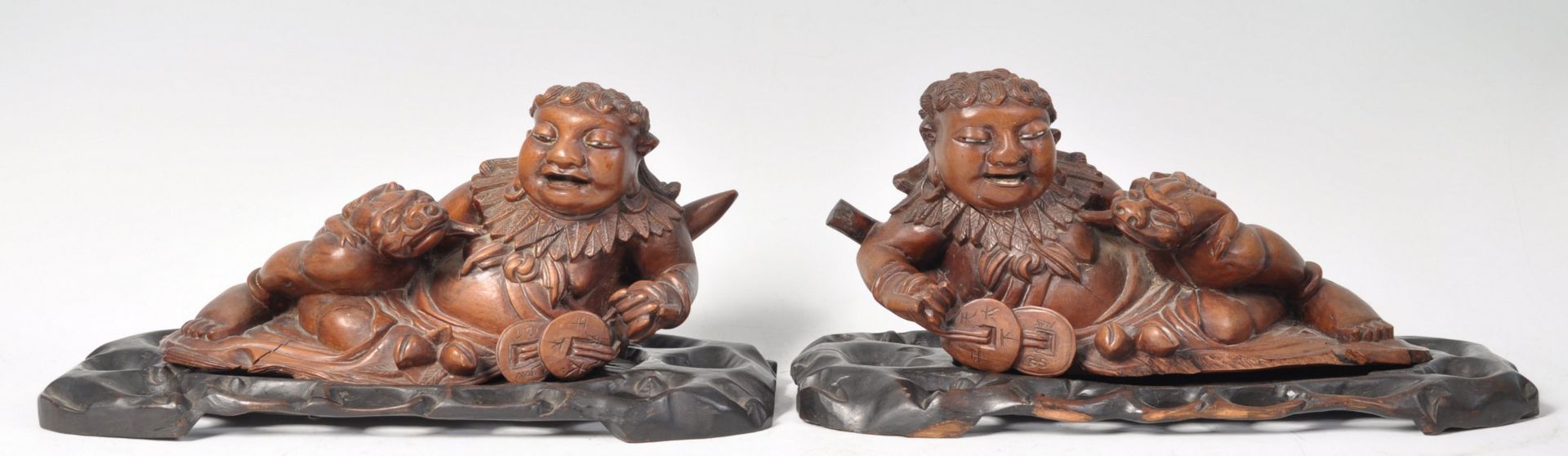 A PAIR OF CHINESE CARVED WOOD FIGURES OF RECLINING
