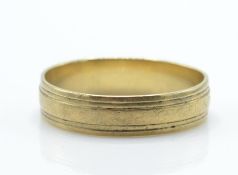A 9ct gold band ring with reeded circumferential