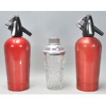A pair of vintage retro soda siphons with red meta