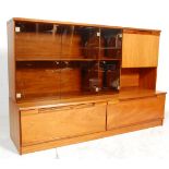 A vintage retro 1970's teak wood wall / entertainment unit having a twin drawer base with a