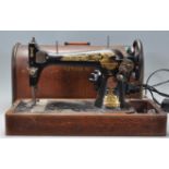 A vintage 20th Century oak cased dome top electric Singer Sewing machine. Good dome carry case