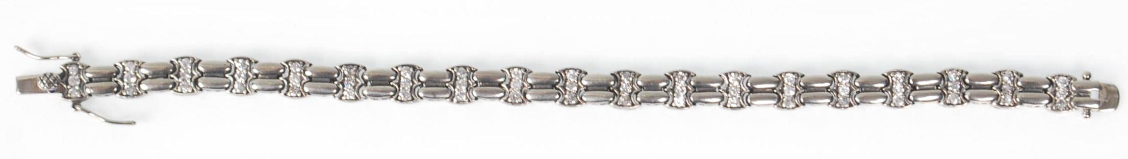 A ladies stamped 925 silver line bracelet being set with three round cut CZ stones with a tongue