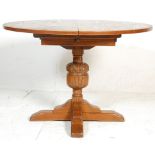 A good 20th Century round oak extending dining table raised on a bulbous carved oak pedestal base.