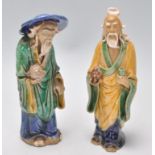 A pair of 1920's Chinese export Ming Dynasty style ceramic figurines in the form of two men glazed