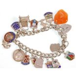 A vintage silver charm bracelet adorned with many charms and having a silver hallmarked heart