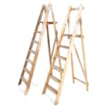 A pair of vintage ladders with one set having graduating steeps and the other straight. 185cm x