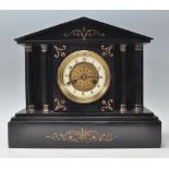 A late 19th Century slate mantel clock having a round face with a white enamelled dial to the