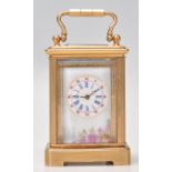 A vintage brass cased miniature carriage clock having porcelain panels to the sides decorated with