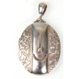A Victorian silver hallmarked locket of oval form having engraved leaf decoration and applied