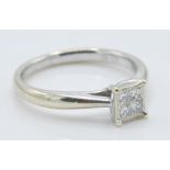 A 9ct white gold ladies ring set with four square cut diamonds to the head. Diamonds estimated at