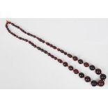 A Cherry Amber Bakelite Style necklace having fifty-three graduating beads. Possible Lucite.