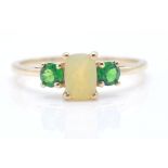A hallmarked 9ct gold dress ring. The ring set with a central yellow stone flanked by 2 green