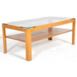 A vintage retro 20th Century low coffee table having rounded supports with a smokey glass top and