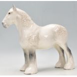 A good Beswick horse porcelain figurine of a dapple grey coloured shire horse and standing alert