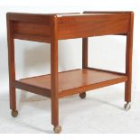 A retro mid 20th Century teak wood two tier tea trolley raised on castors having a double side