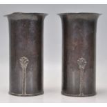 A good matching pair of Arts and Crafts copper vases having flared rims with applied flower stem
