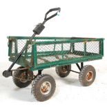 A metal four wheel pull along trolley finished in green with fold down sides. 85cm x 105cm x 55cm.