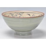 A 20th Century Japanese studio pottery footed bowl having hand painted floral panels to the interior