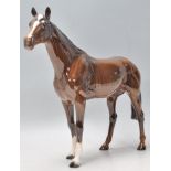 A good 20th century Beswick horse porcelain figurine of a horse having a dark coat with brushed tail