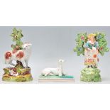 A group of three 19th Century Staffordshire figurines to include a Greyhound / whippet figure raised