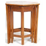 An early 20th Century Art Deco walnut nest of three tables of octagonal form raised on square