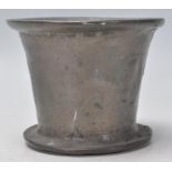 An 18th Century cast bronze pestle of bell form having a flared rim, with worn medallions to the