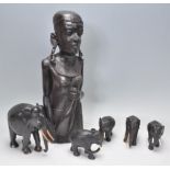 An African tribal carved ebony wood sculpture of a woman with water carrier in hand having pierced