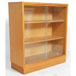 A 20th Century retro oak bookcase cabinet in the manner of Herbert GIbbs having two interior