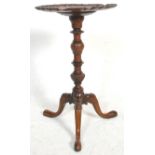 A 19th Century solid mahogany pie crust pedestal wine table raised on a turned column terminating in