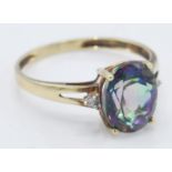 A stamped 9k yellow gold ladies dress ring set with a single faceted cut mystic topaz stone