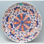 A 19th century Chinese Imari pattern wall charger of bowled form having geometric central swirl