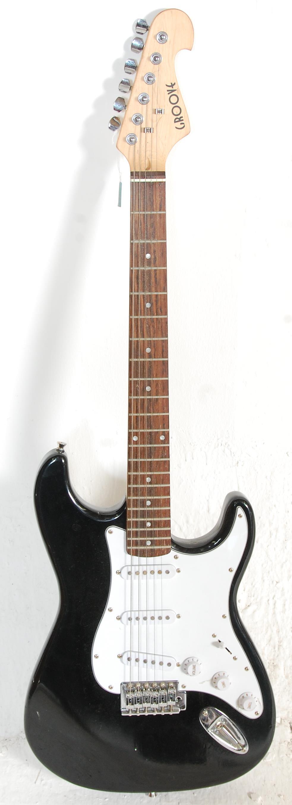 A good Fender style six string electric guitar by Groove having a white scratch guard and black body