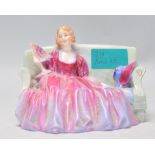 A Royal Doulton 20th century porcelain figurine entitled Sweet & Twenty being stamped to the