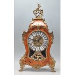 An antique Rococo style German marquetry clock having brass C scroll and acanthus leaf decoration