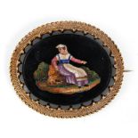 A late 19th / early 20th Century antique brooch having an oval black stone panel with micro mosaic
