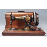 A vintage Jones Family C. S. hand crank sewing machine having gilt decoration and set within a