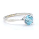 A 9ct white gold and zircon solitaire ring. The ring set with a round mix cut blue zircon in a