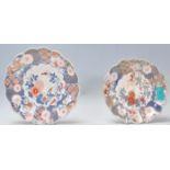 A pair of 19th Century Japanese Imari hand painted plates having scalloped rims being hand painted