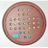 A 20th Century solitaire board game having a full set of coloured swirl glass marbles on a