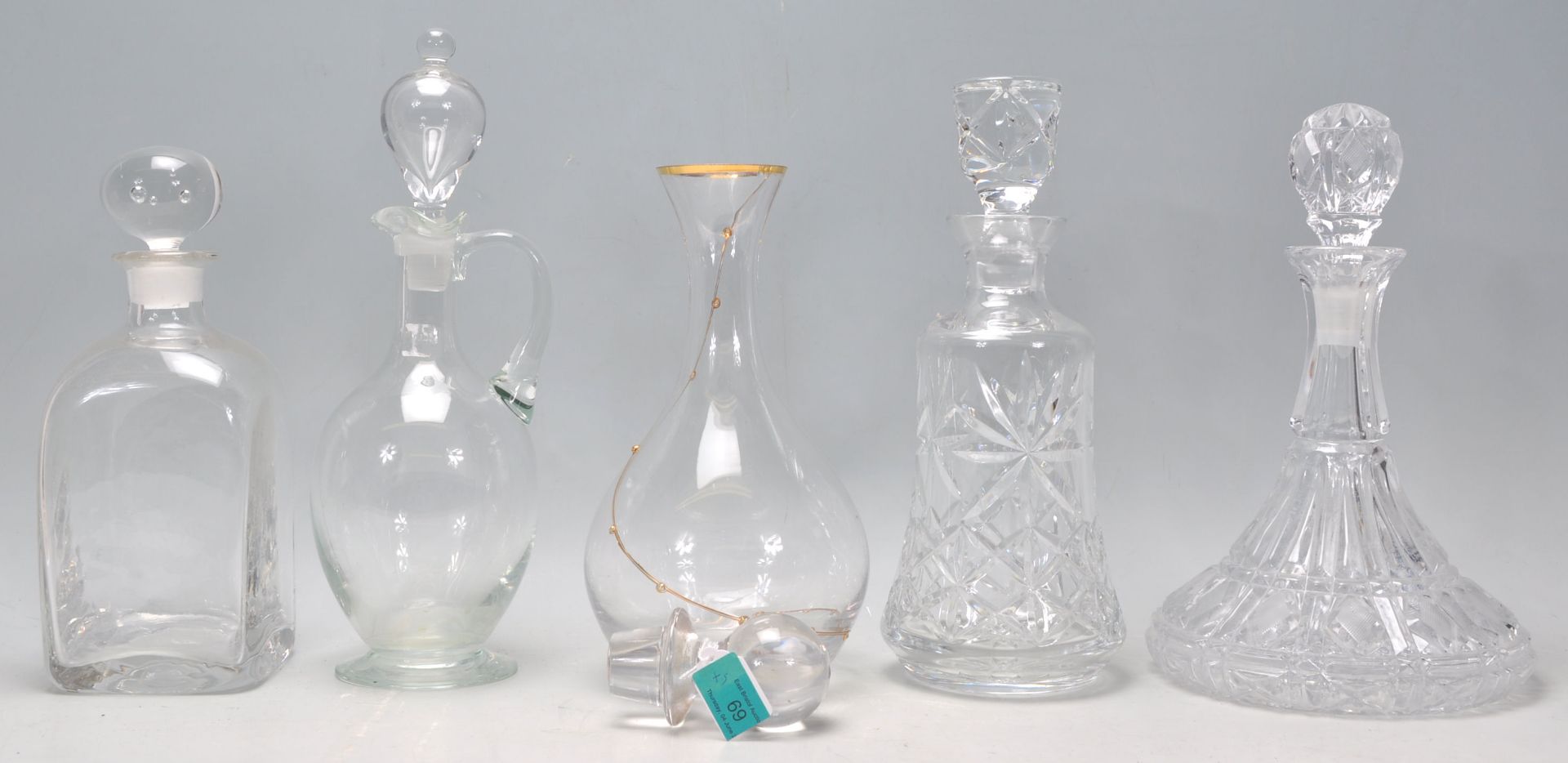 A mixed group of five glass decanters of various shapes and sizes to include a etched ships