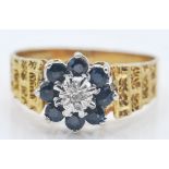 A 1970's hallmarked 9ct gold sapphire and diamond cluster ring. The ring having a central illusion