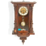 An early 20th Century Vienna regulator pendulum wall clock being mahogany cased with turned