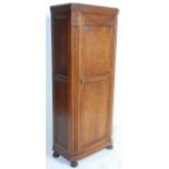 A 1920's carved oak hall cupboard wardrobe in the Jacobean revival style. Raised on bun feet with