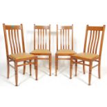 A set of four early 20th Century Edwardian Arts & Crafts solid oak rail back dining chairs having