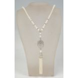 A ladies long pearl necklace threaded with graduating beads having a white metal pendant with a