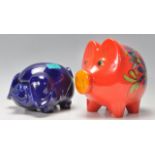 Two retro mid 20th Century ceramic piggy banks in the forms of two pigs with finished in a blue