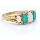 A hallmarked 9ct gold opal and green stone dress ring. The ring with opal like cabochons, possibly