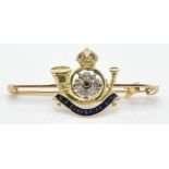 A 15ct bar-mounted regimental brooch in gold ruby and diamonds with enamel work finish for the Kings