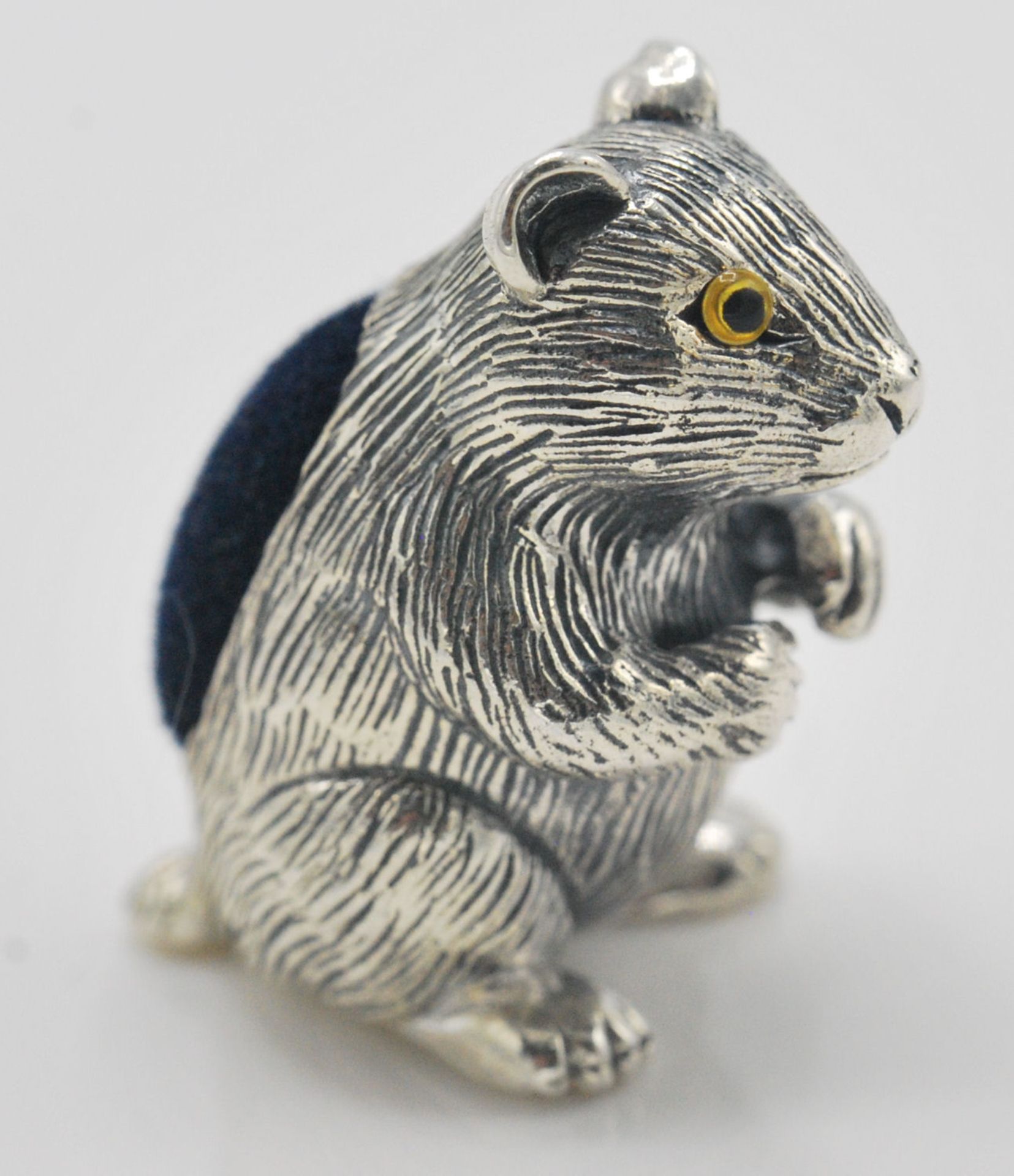 A stamped 925 silver pincushion in the form of a hamster with yellow glass eyes and a blue velvet